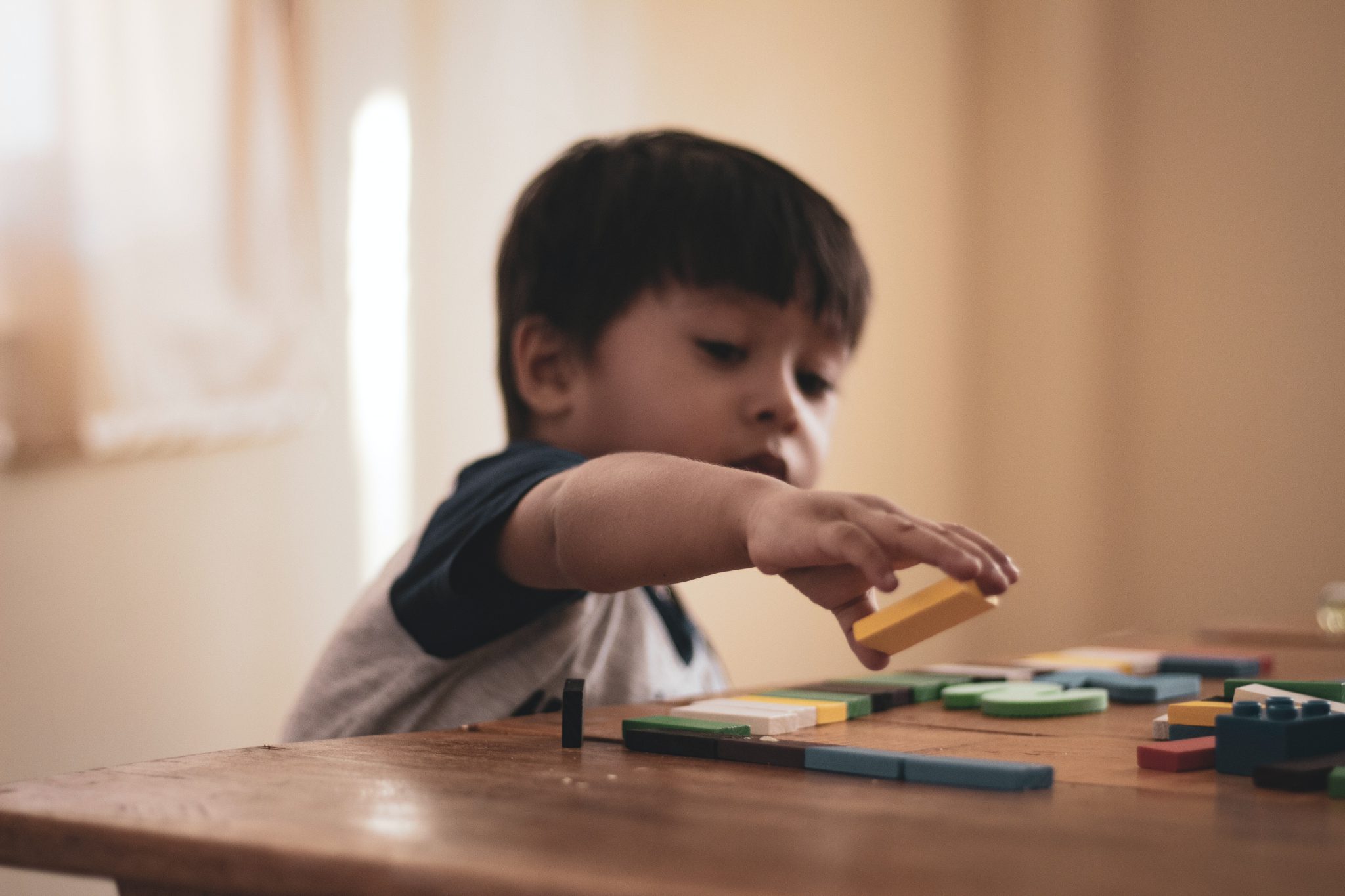 Jongetje dat met blokkenspeelt en misschien autisme heeft