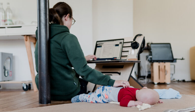 werken na verlof / moeder werkt met baby op de grond