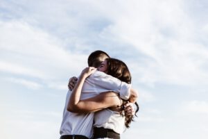 vriend / man en vrouw knuffelen in buitenlucht